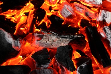 Photo of Pieces of hot smoldering coal as background, closeup