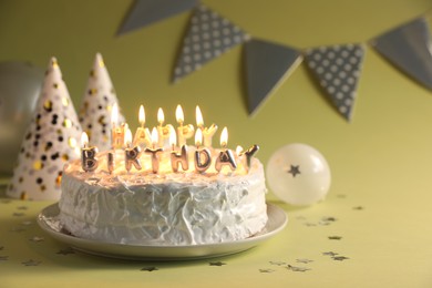 Tasty birthday cake with burning candles on green background, closeup. Space for text