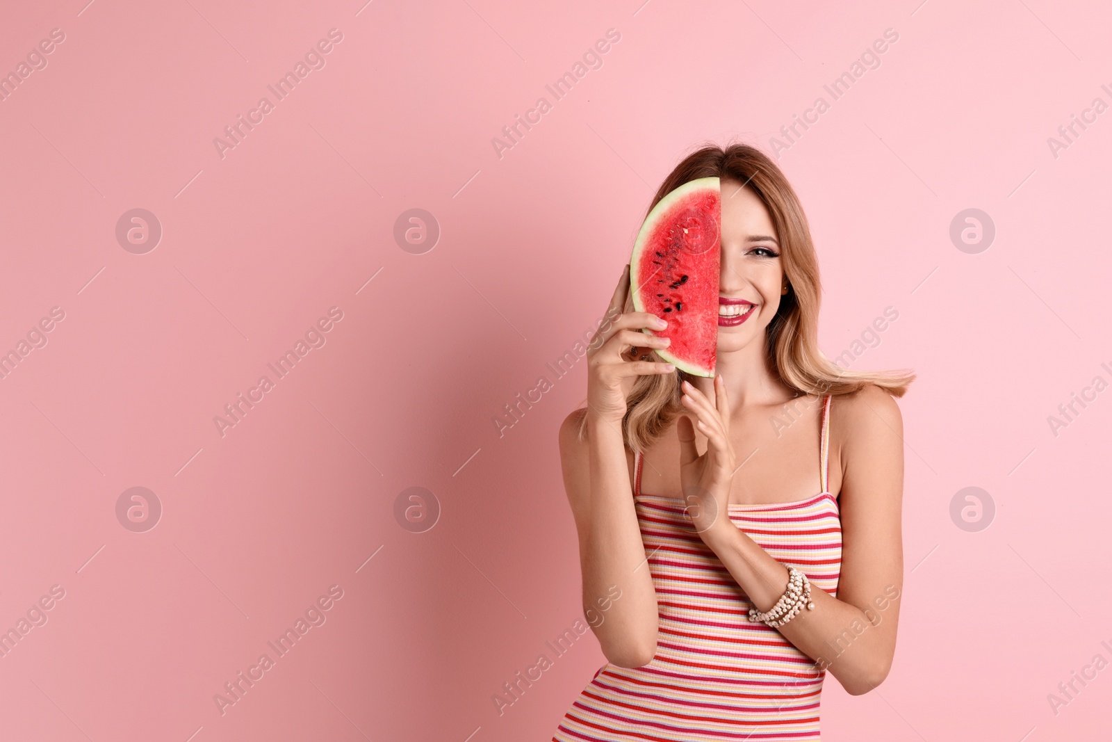 Photo of Pretty young woman with juicy watermelon on color background