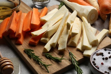 Photo of Raw parsnips, carrots and other products on light grey table