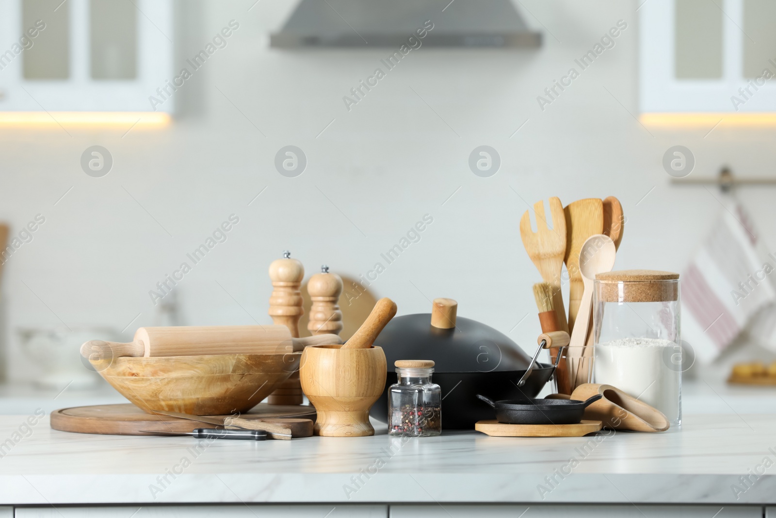 Photo of Set of cooking utensils and products on white table against blurred background