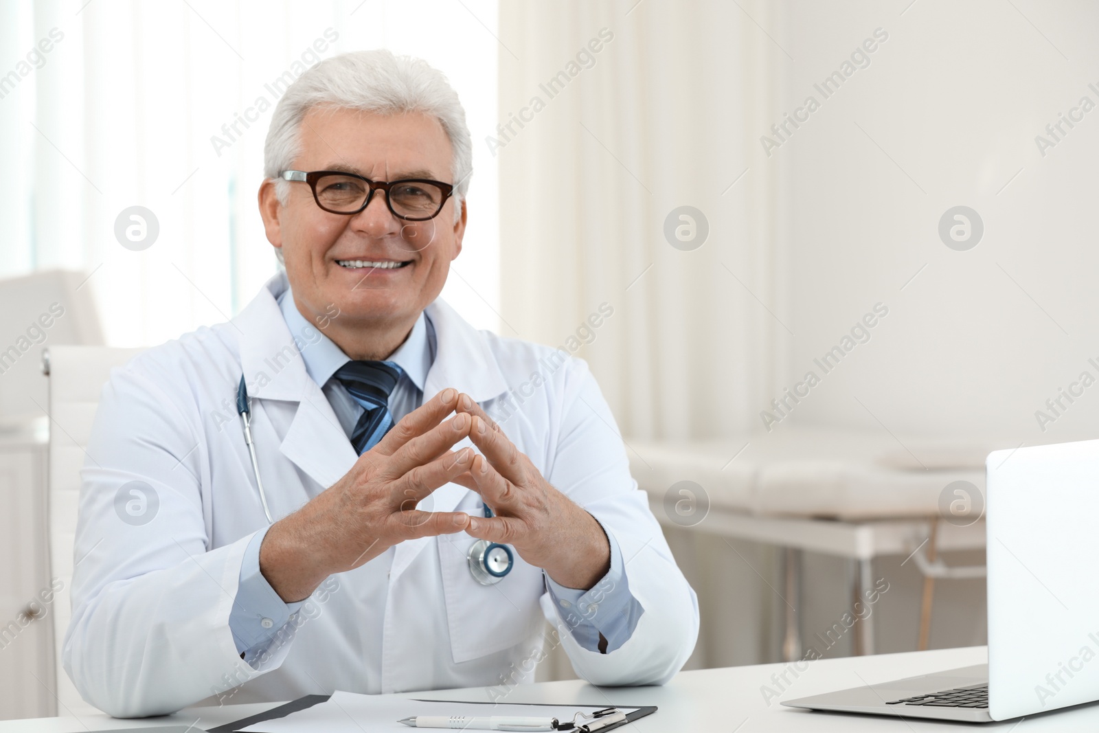 Photo of Portrait of senior doctor in white coat at workplace