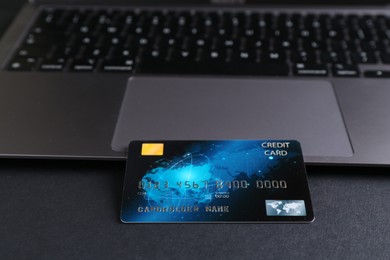 Photo of Credit card and laptop on grey table, closeup