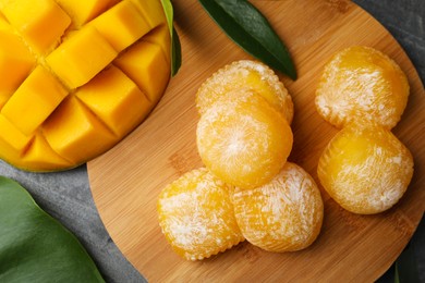 Photo of Delicious mango mochi on grey table, flat lay