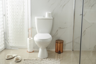 Photo of Toilet bowl near shower stall in modern bathroom interior