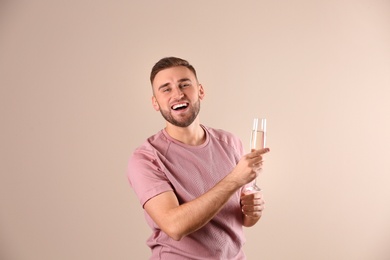 Portrait of happy man with champagne in glass on color background