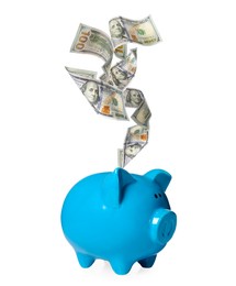 Image of Dollar banknotes falling into blue piggy bank on white background