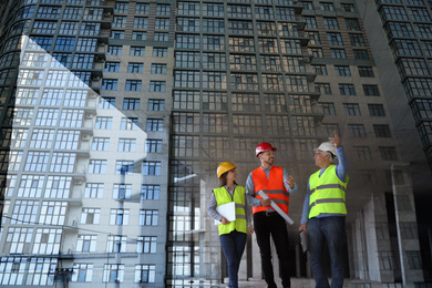 Double exposure of engineers at construction site and modern building