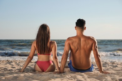 Photo of Lovely couple spending time together on beach, back view