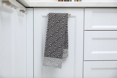 Clean towel on cabinet door in kitchen