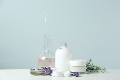 Herbal cosmetic products, laboratory glassware and ingredients on white table