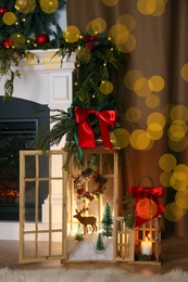 Photo of Beautiful Christmas lanterns near fireplace in room with festive decor