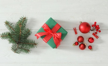 Photo of Flat lay composition with Christmas gift box on white wooden table