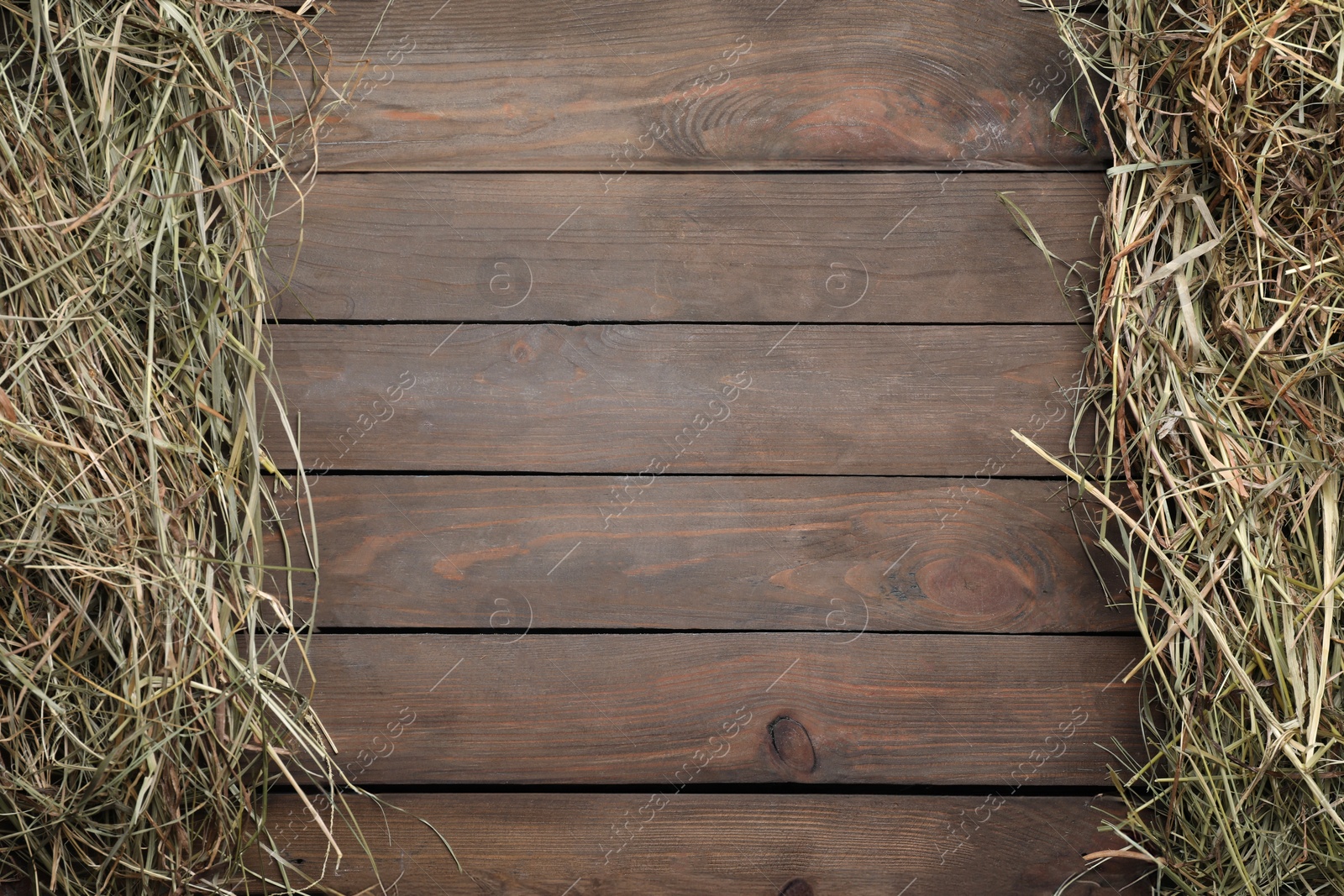 Photo of Frame made of dried hay on wooden table, top view. Space for text