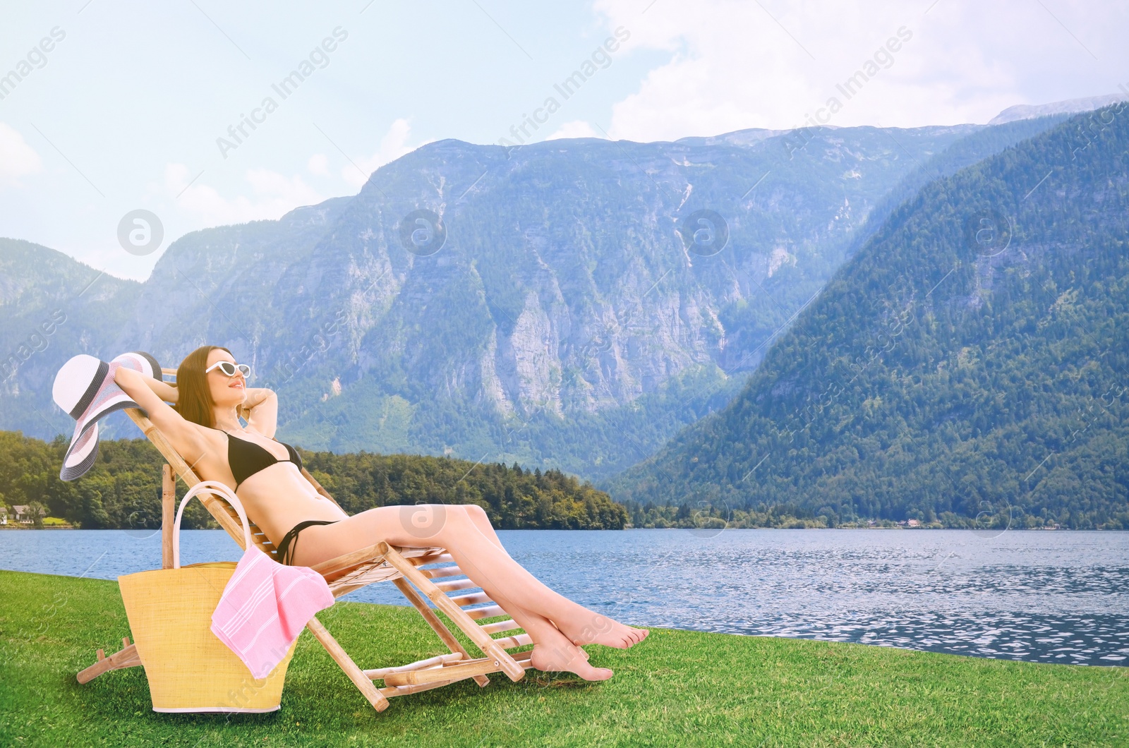 Image of Young woman relaxing on sun lounger near river and mountains. Luxury vacation 