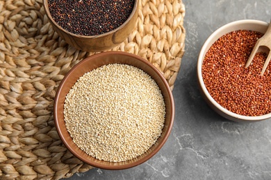 Flat lay composition with different types of quinoa on grey background