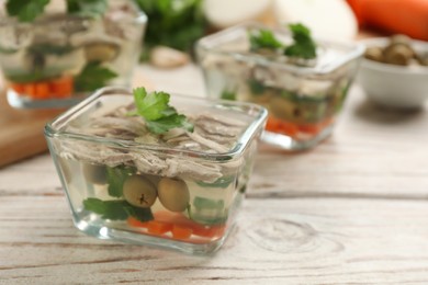 Delicious aspic in glass bowl on white wooden table, closeup