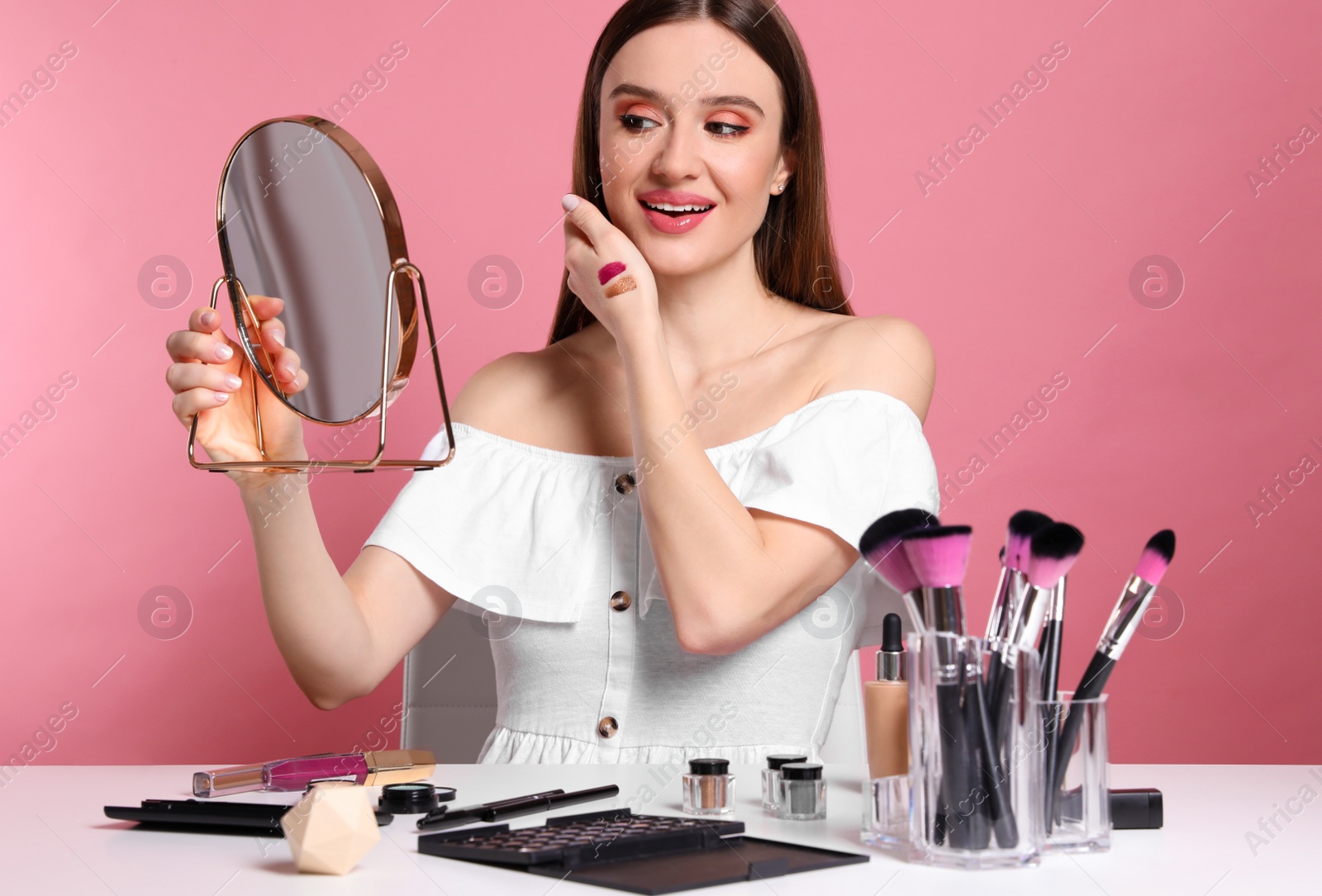 Photo of Beauty blogger with mirror on pink background