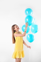 Photo of Young woman with air balloons on white background