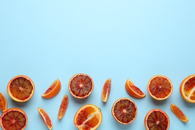 Photo of Many ripe sicilian oranges on light blue background, flat lay. Space for text