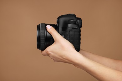 Photo of Photographer with camera on brown background, closeup