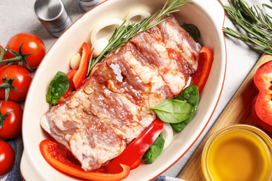 Photo of Raw spare ribs with garnish on light table, closeup
