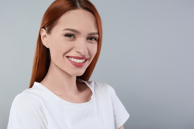 Portrait of beautiful young woman on light gray background, space for text