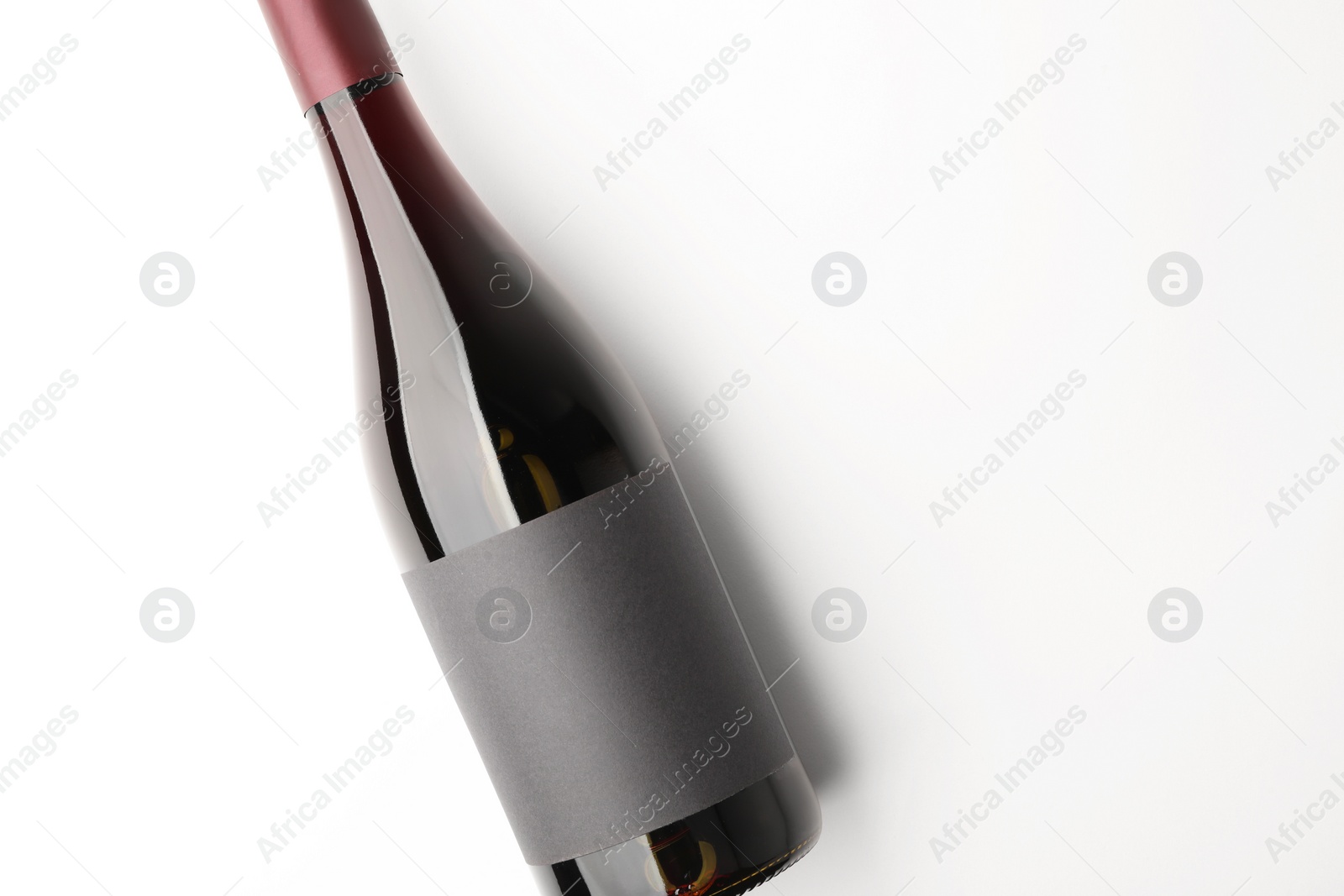 Photo of Bottle of tasty red wine on white background, top view. Space for text