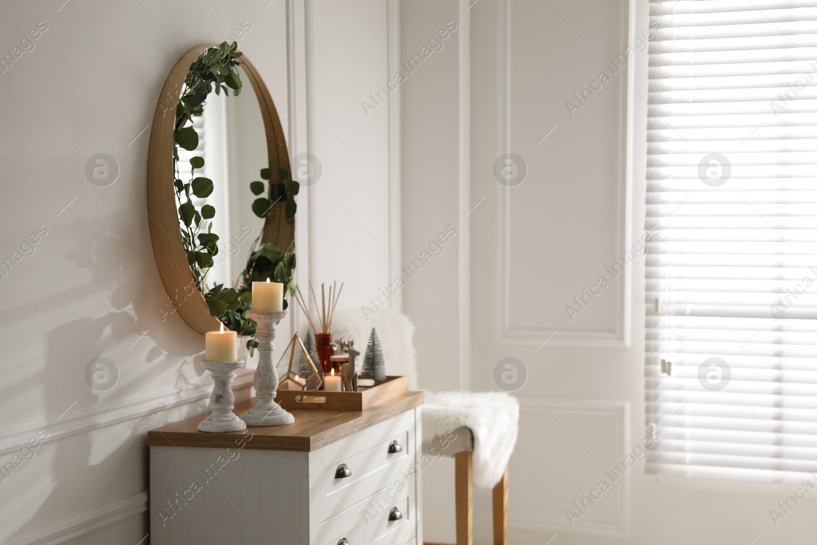 Photo of Modern room interior with chest of drawers and mirror on white wall