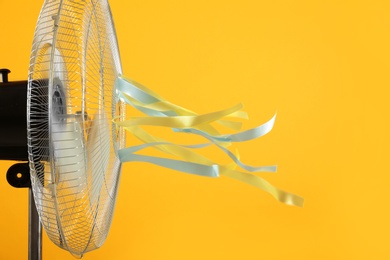 Photo of Electric fan on yellow background. Summer heat