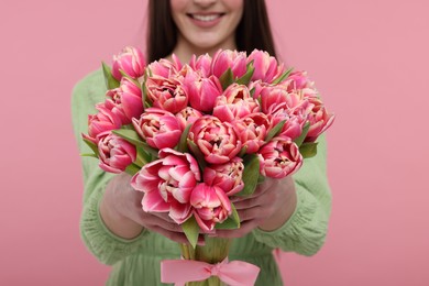 Photo of Happy woman with beautiful bouquet on dusty pink background, closeup