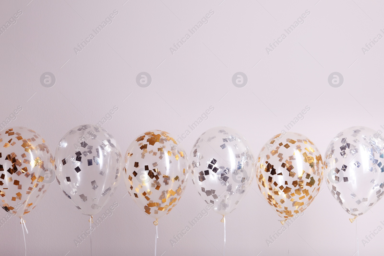 Photo of Color balloons with ribbons on white background