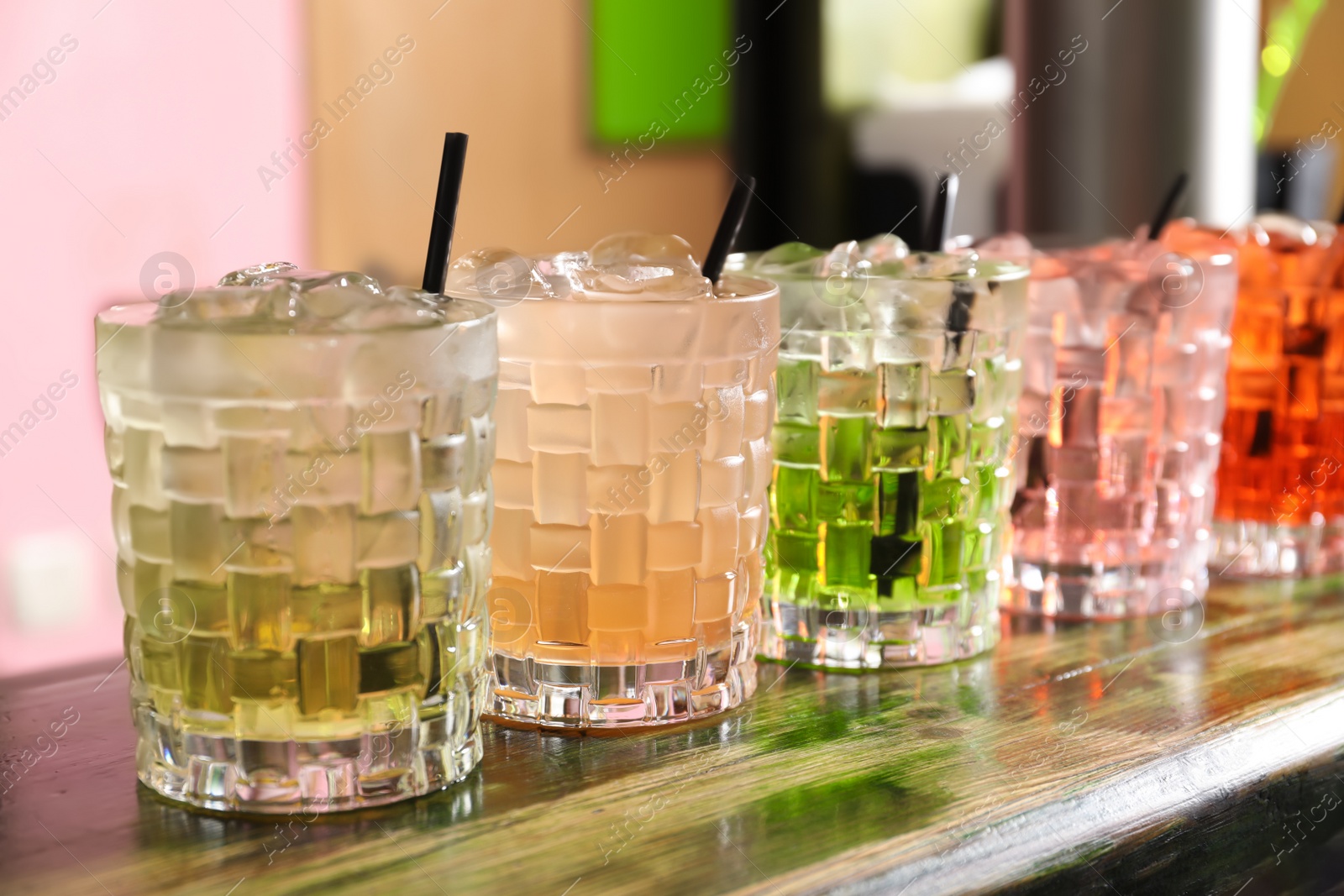 Photo of Glasses of delicious cocktails with ice on table