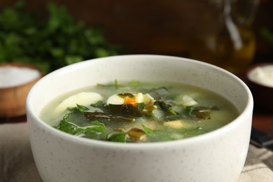 Delicious sorrel soup in white ceramic bowl, closeup