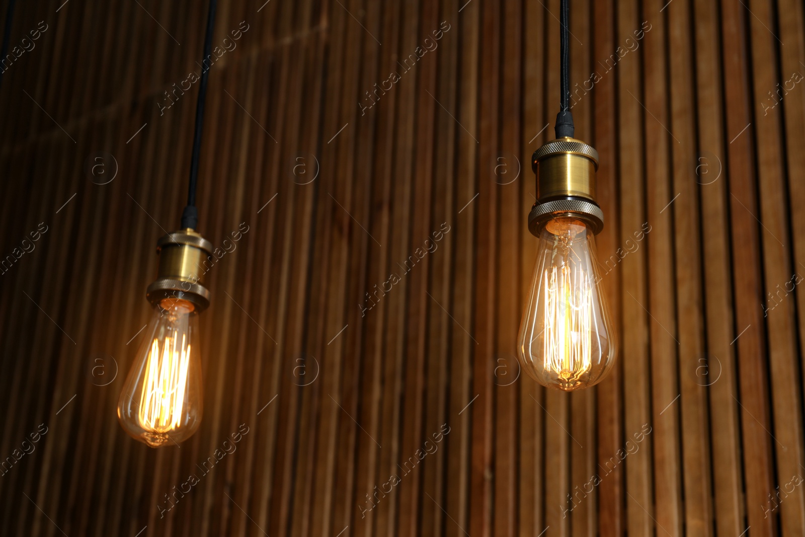 Photo of Pendant lamps with light bulbs on wooden background