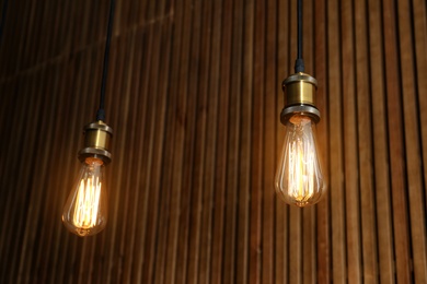 Pendant lamps with light bulbs on wooden background