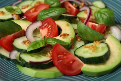 Photo of Tasty salad with cucumbers on blue plate, closeup
