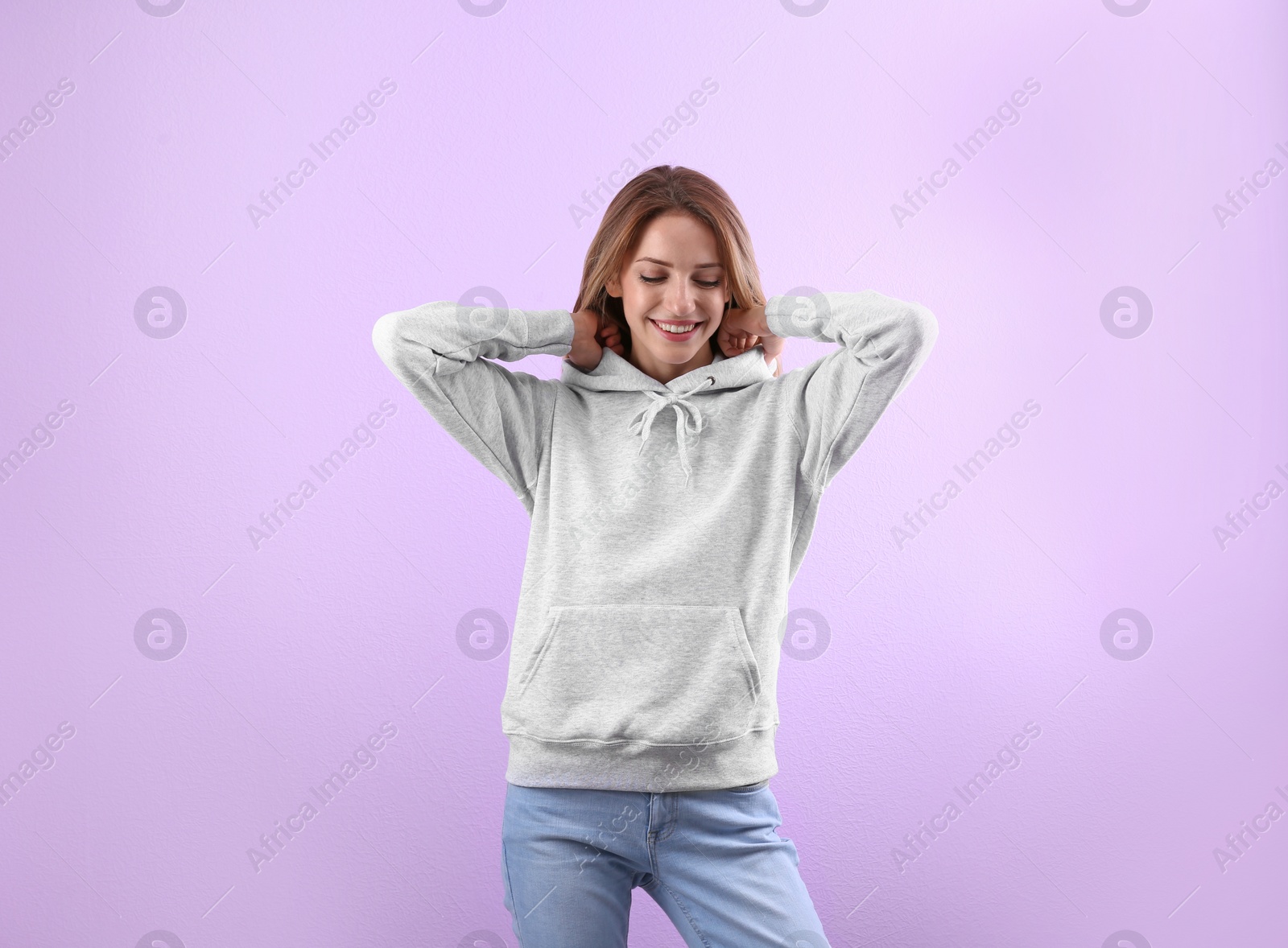 Photo of Portrait of woman in hoodie sweater on color background. Space for design