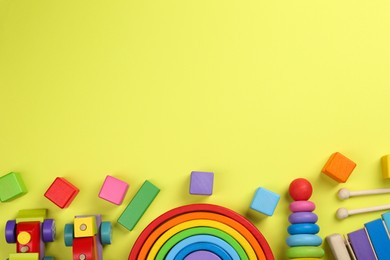 Photo of Different children's toys on yellow background, flat lay. Space for text