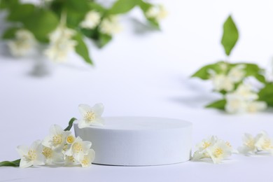 Photo of Presentation of product. Podium and beautiful jasmine flowers on white background