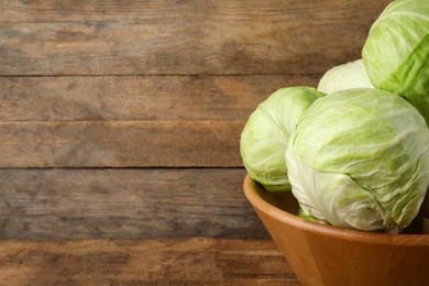 Photo of Ripe white cabbage on wooden background, closeup. Space for text