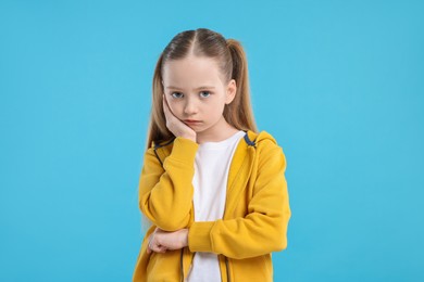 Photo of Portrait of sad girl on light blue background