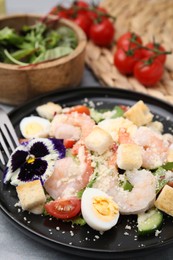 Delicious Caesar salad with shrimps served on grey table, closeup