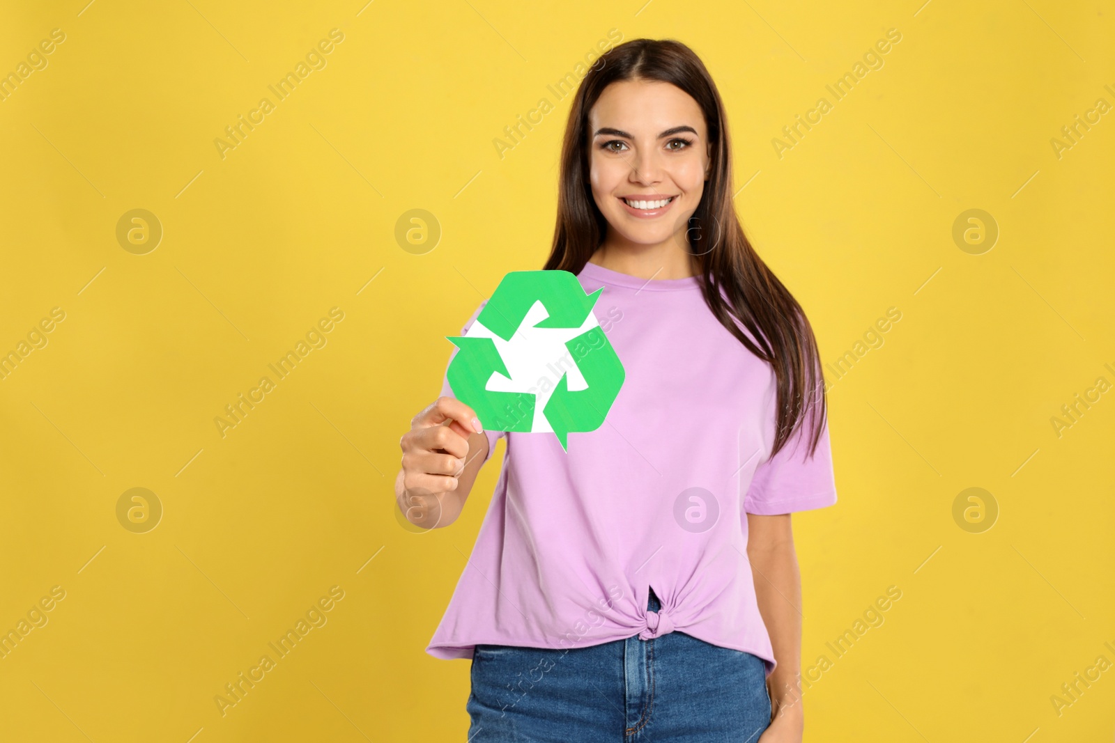 Photo of Young woman with recycling symbol on yellow background