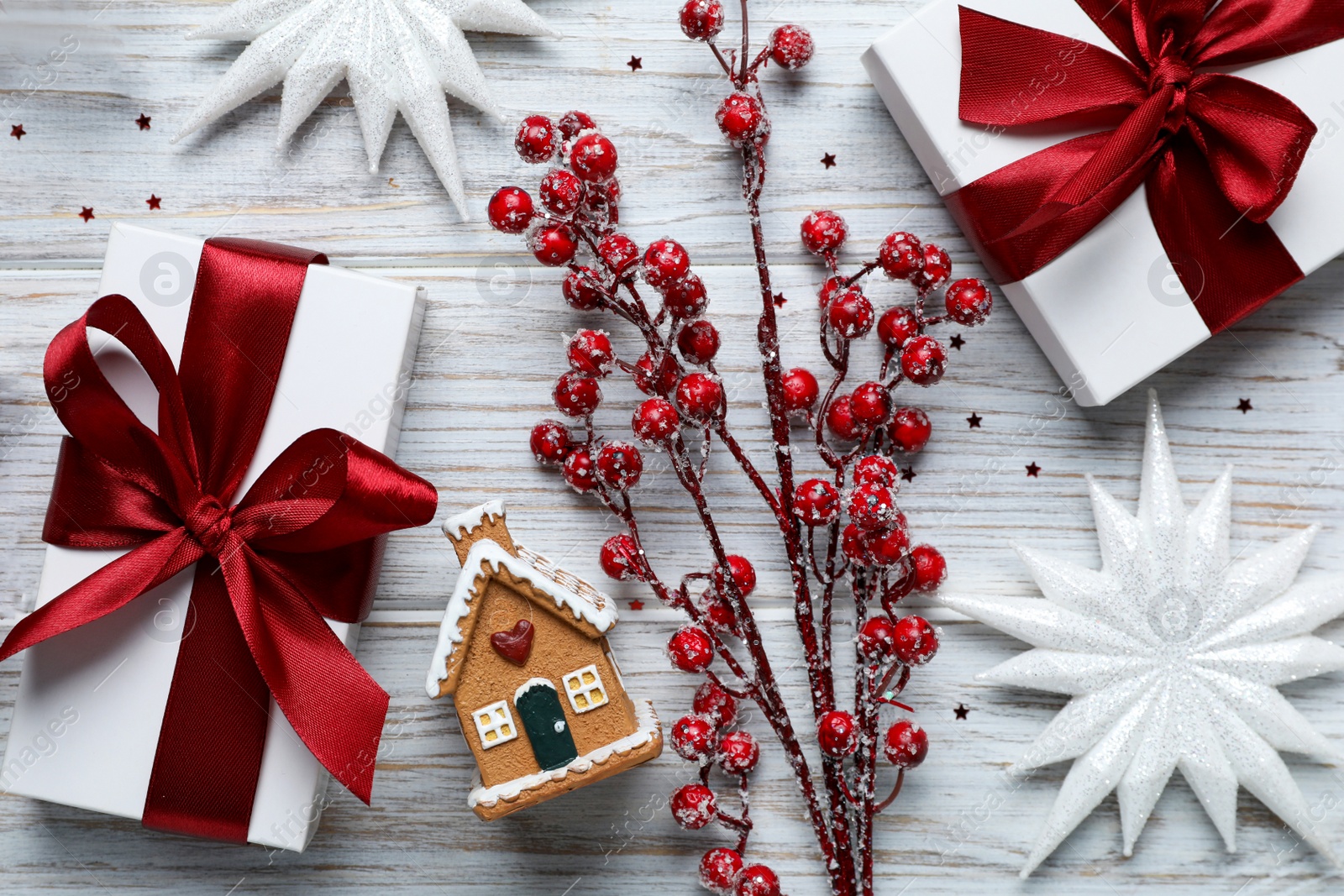 Photo of Flat lay composition with beautiful gift boxes and different Christmas decor on white wooden table