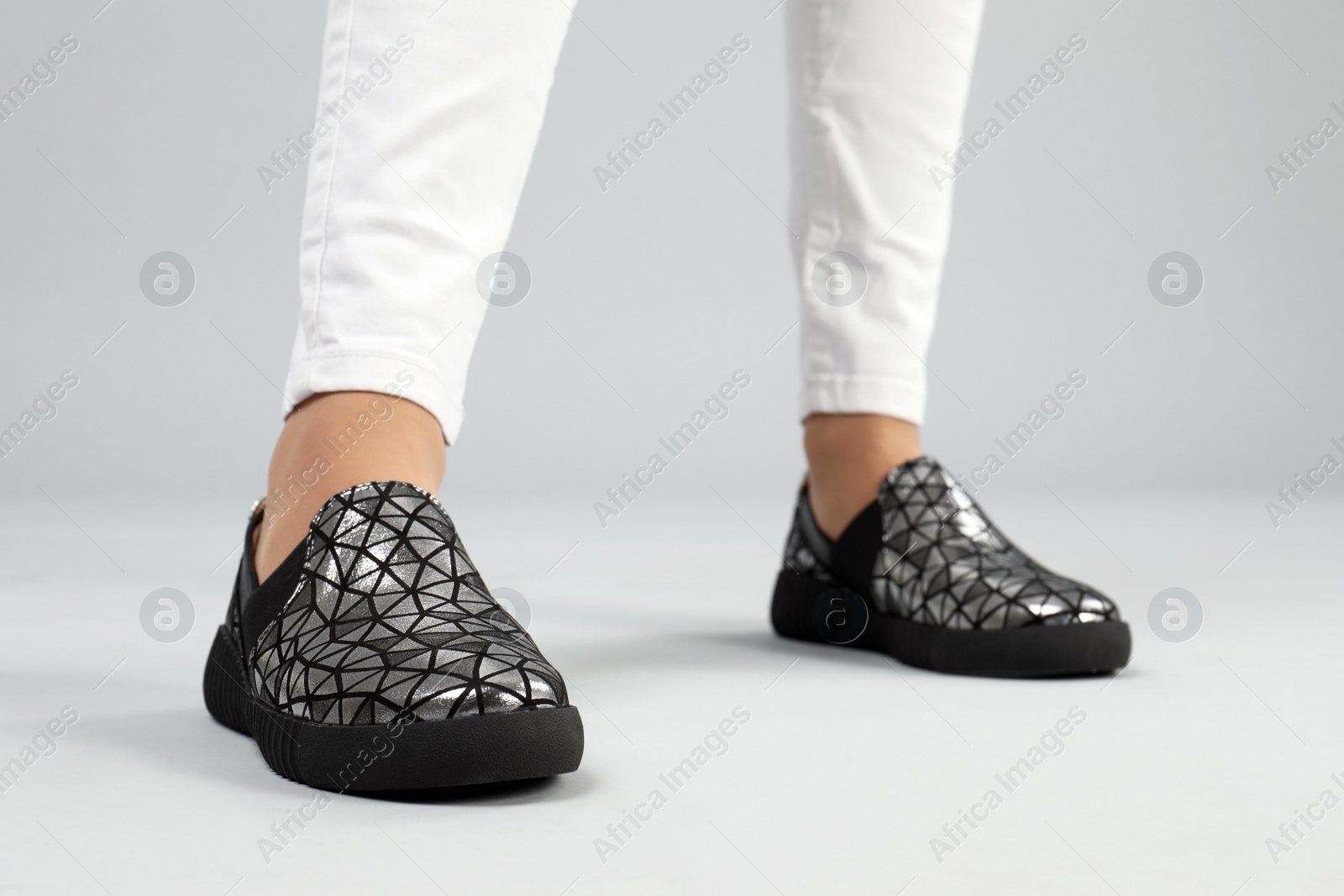 Photo of Woman in stylish shoes on grey background, closeup