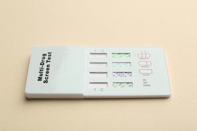 Photo of Multi-drug screen test on beige background, closeup