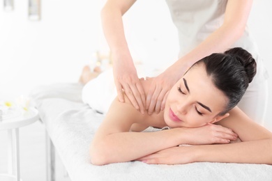 Photo of Young woman receiving massage in spa salon