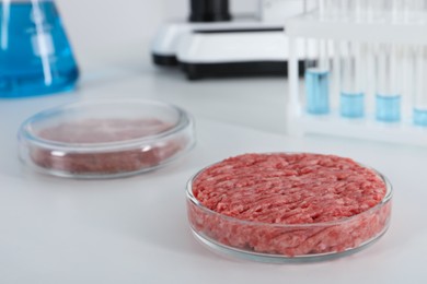 Photo of Petri dish with raw minced cultured meat on white table in laboratory, space for text