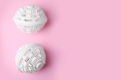 Laundry dryer balls on pink background, flat lay. Space for text